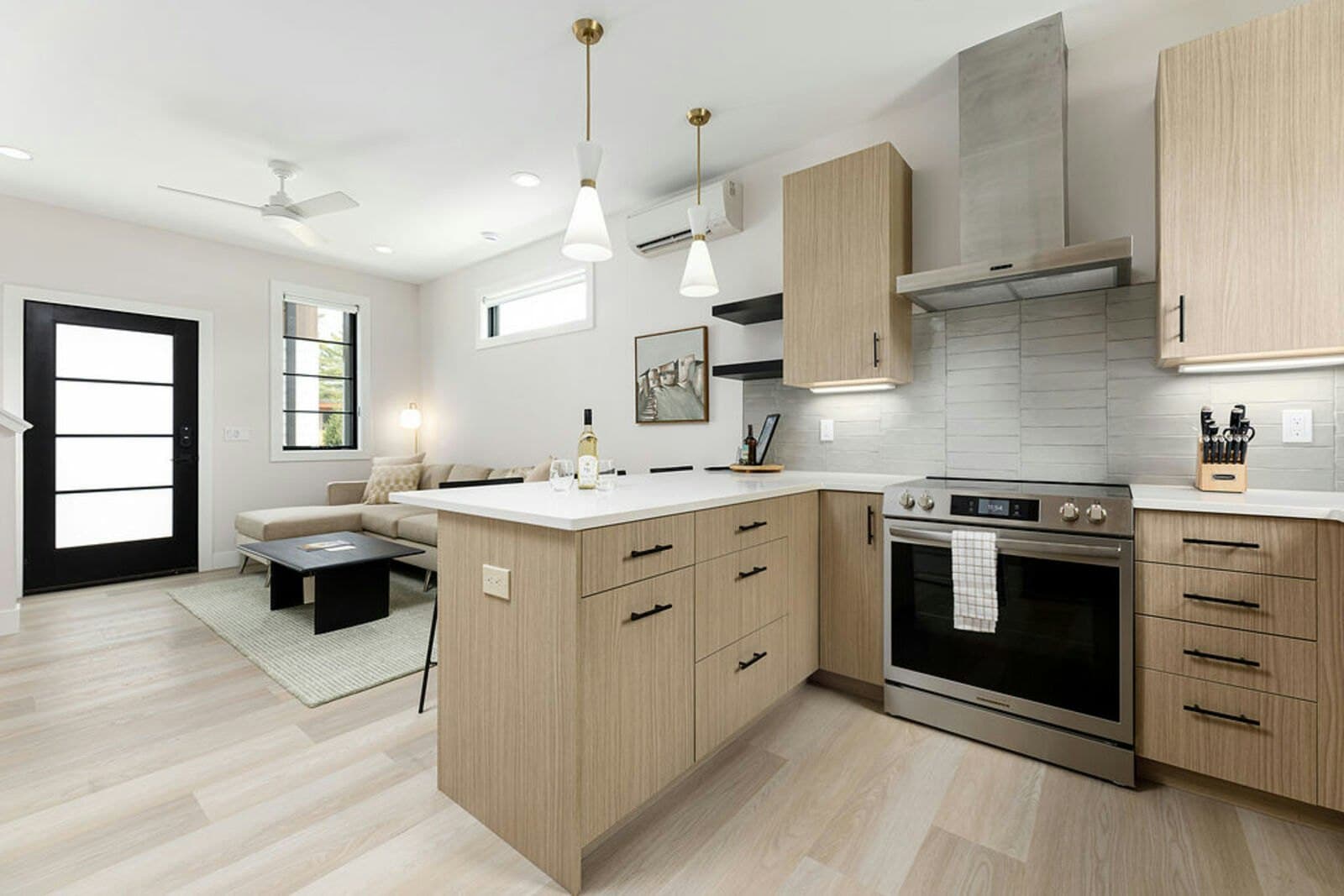 Kitchen island, range, and living area beyond