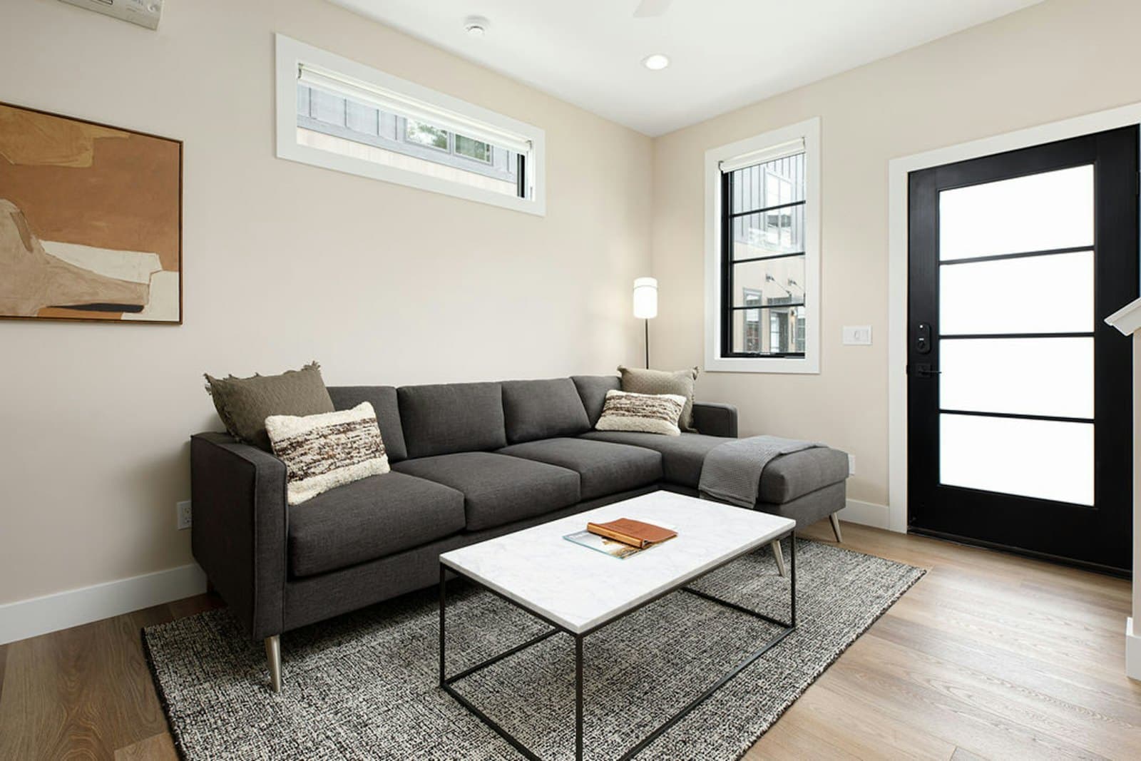 Living room with charcoal sectional and marble coffee table