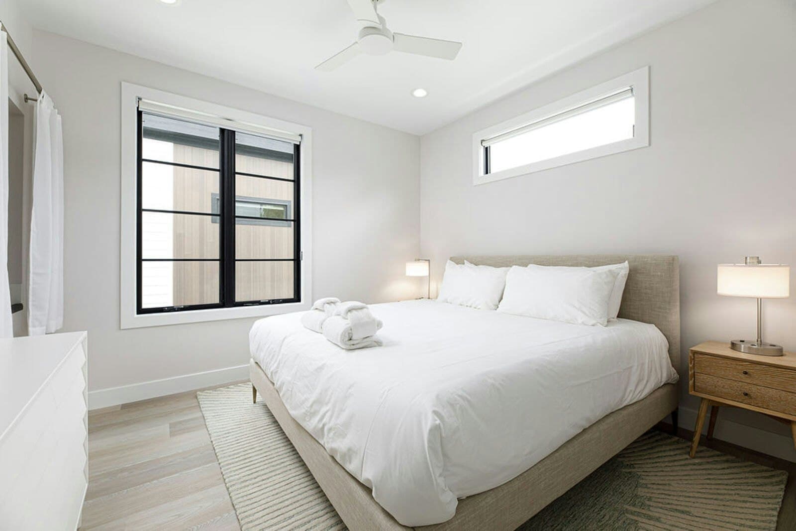 Bedroom with robes, nightstands, and black-framed window