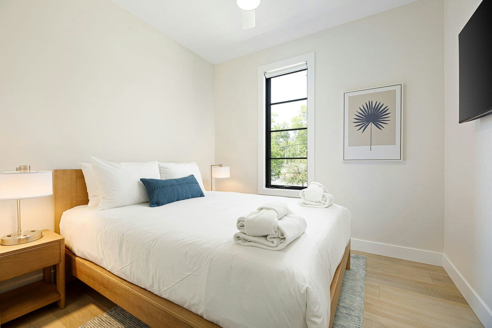 Bedroom with wood frame bed and courtyard window
